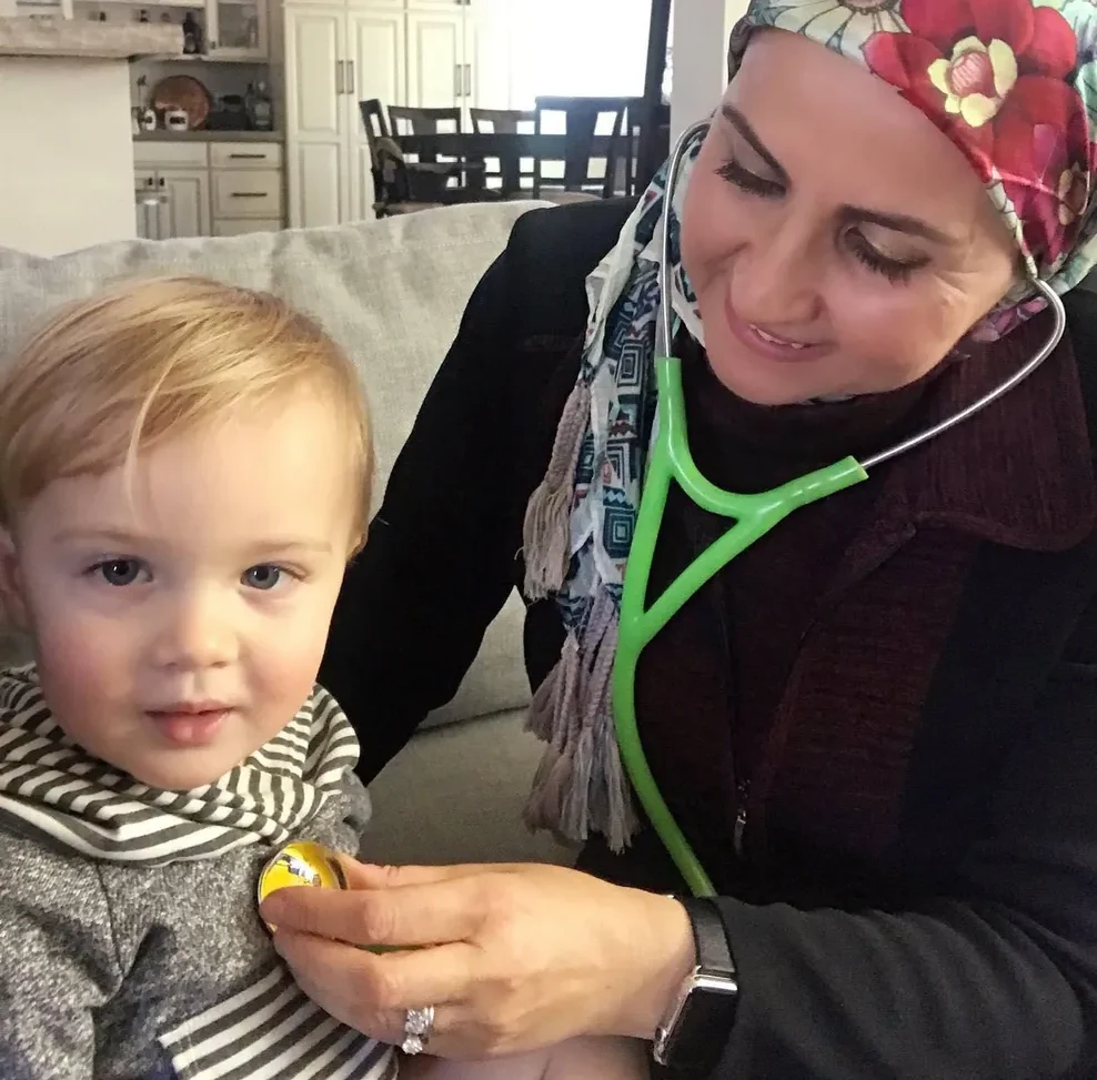 Dr. Suhir Bitar examining a toddler with a stethoscope at home